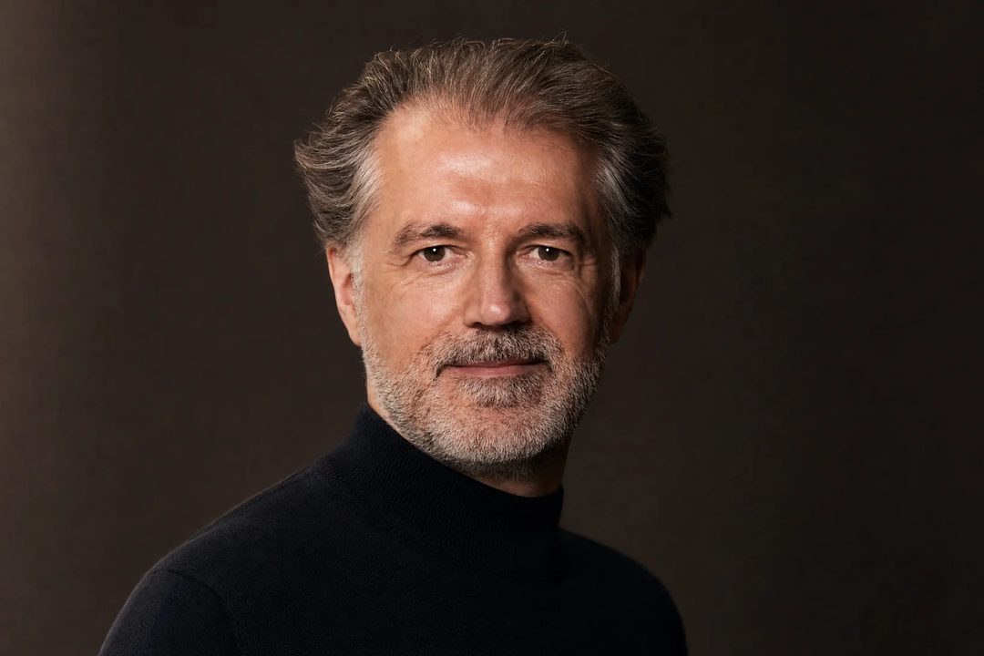 Alexander Renner im schwarzen Rollkragen, dunkler Hintergrund